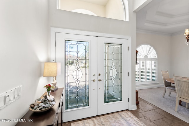 entryway with ornamental molding and french doors