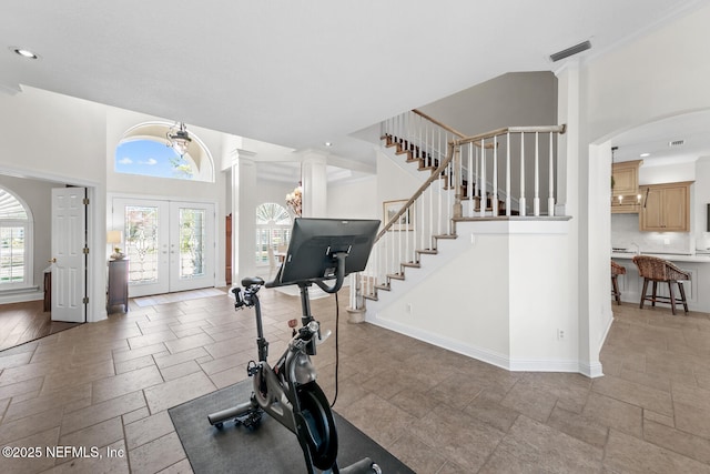 exercise room featuring french doors and an inviting chandelier