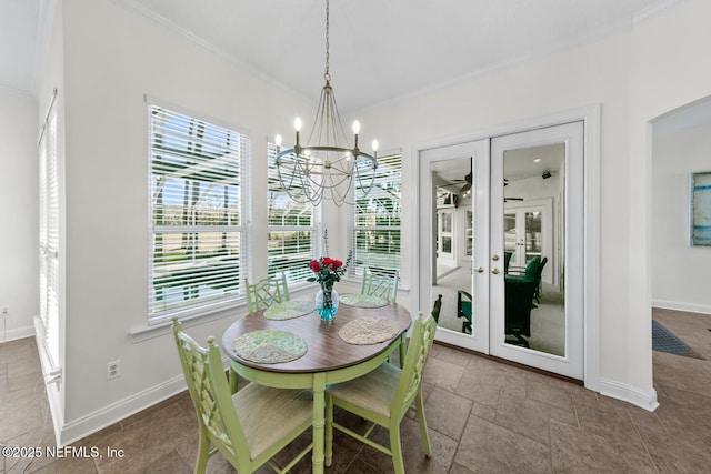 dining area featuring a chandelier, a healthy amount of sunlight, crown molding, and french doors