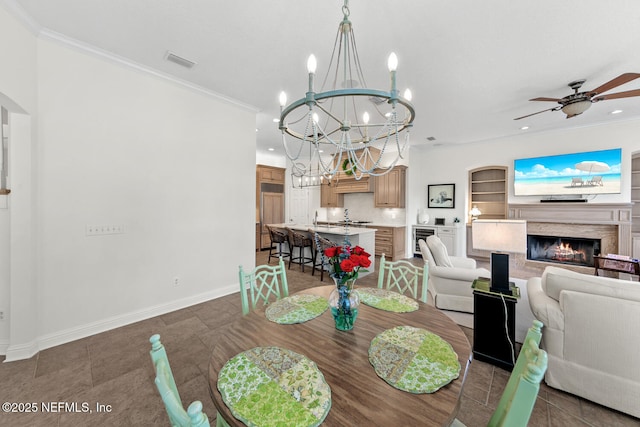 dining space with built in features, beverage cooler, ornamental molding, and ceiling fan