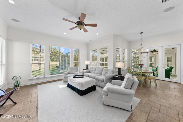 living room with ceiling fan with notable chandelier, plenty of natural light, a textured ceiling, and french doors