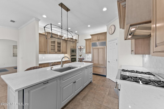 kitchen featuring sink, built in appliances, crown molding, a kitchen island with sink, and custom range hood