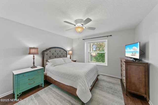 bedroom featuring ceiling fan, dark hardwood / wood-style flooring, and a textured ceiling