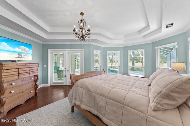 bedroom with a tray ceiling, french doors, dark wood-type flooring, and access to outside