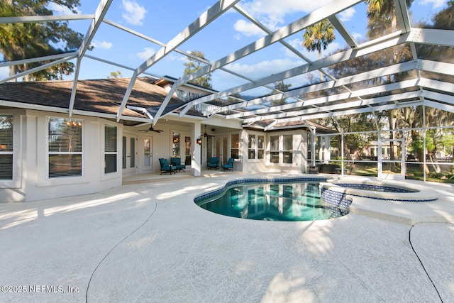 view of swimming pool with ceiling fan, a patio area, a lanai, and an in ground hot tub