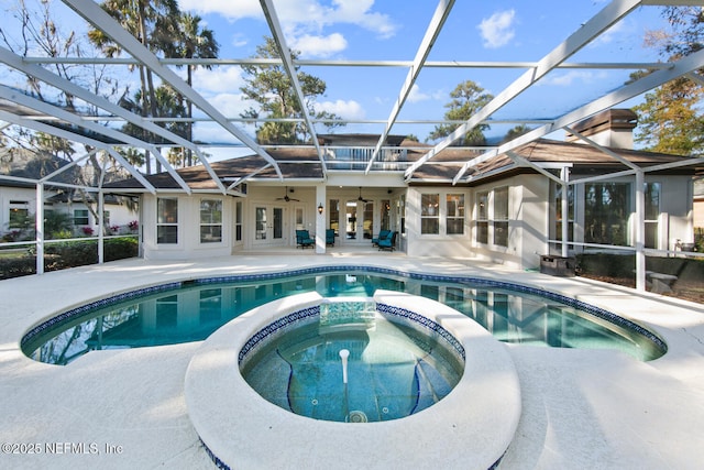 view of swimming pool with a lanai, an in ground hot tub, a patio, and french doors