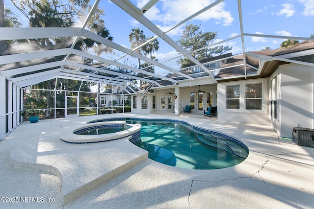 view of pool with an in ground hot tub, glass enclosure, ceiling fan, and a patio area