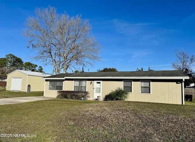 view of front of home featuring a front yard, a garage, and an outdoor structure