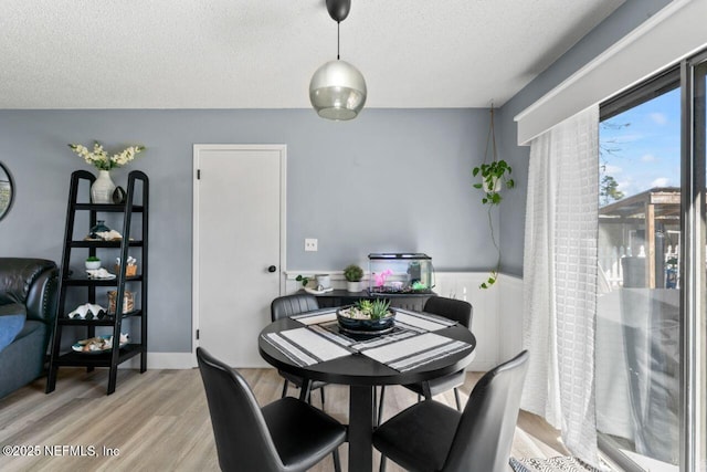 dining area with hardwood / wood-style flooring and a textured ceiling