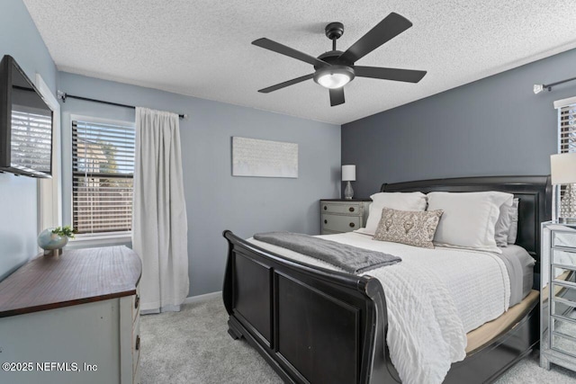 bedroom featuring ceiling fan, light carpet, and a textured ceiling