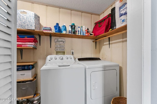 clothes washing area with separate washer and dryer and a textured ceiling