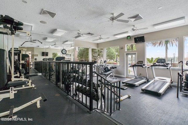 workout area with ceiling fan and a textured ceiling