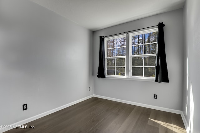 empty room with dark hardwood / wood-style flooring