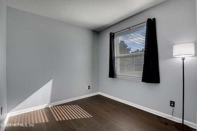 spare room featuring dark wood-type flooring