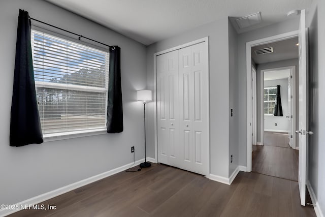 unfurnished bedroom featuring dark hardwood / wood-style floors and a closet