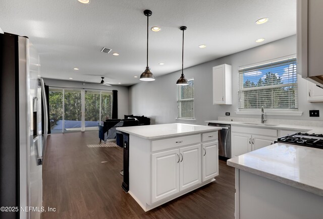 kitchen featuring white cabinetry, sink, a kitchen island, and appliances with stainless steel finishes