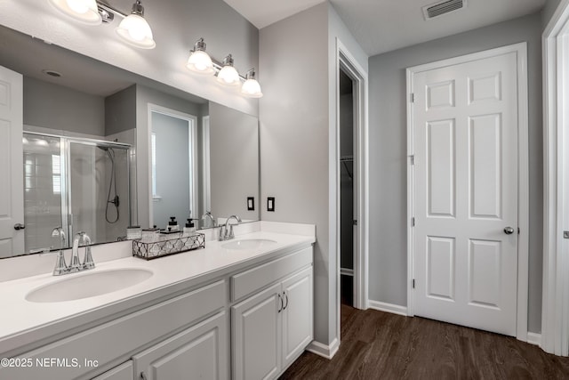 bathroom featuring a shower with door, vanity, and hardwood / wood-style floors