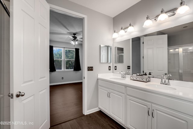 bathroom featuring ceiling fan, hardwood / wood-style floors, an enclosed shower, a textured ceiling, and vanity