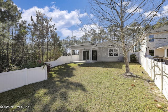 rear view of house featuring a lawn and a patio