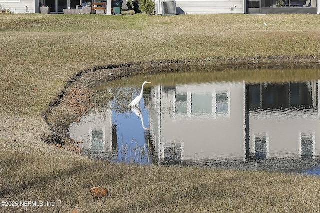 exterior space featuring a yard, a water view, and central AC