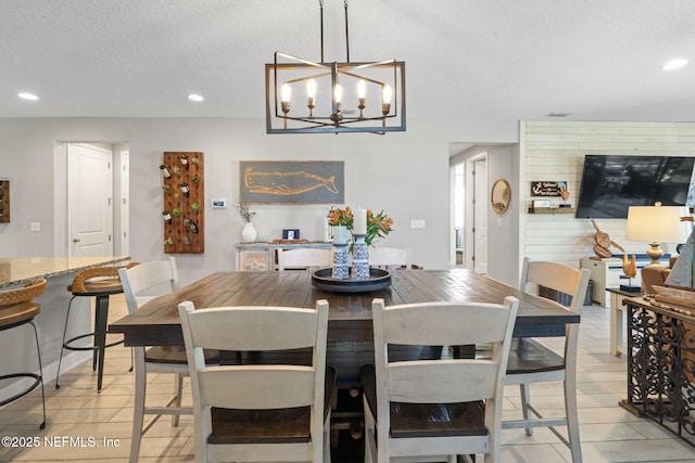 tiled dining area with a textured ceiling and an inviting chandelier