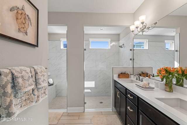 bathroom featuring tile patterned flooring, a tile shower, vanity, and a healthy amount of sunlight