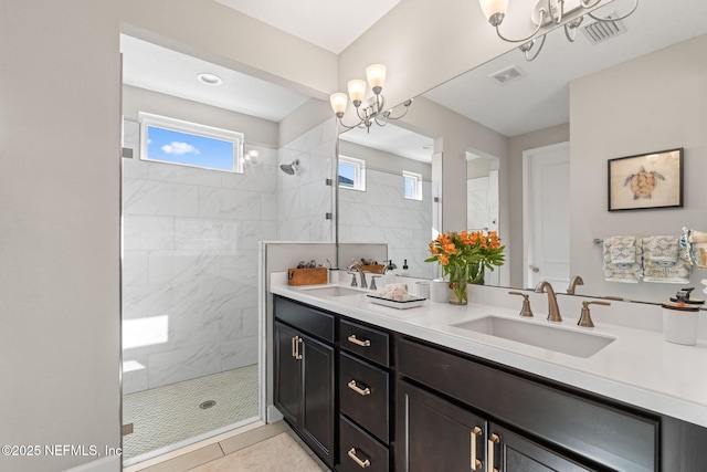 bathroom featuring tile patterned floors, vanity, a chandelier, and tiled shower