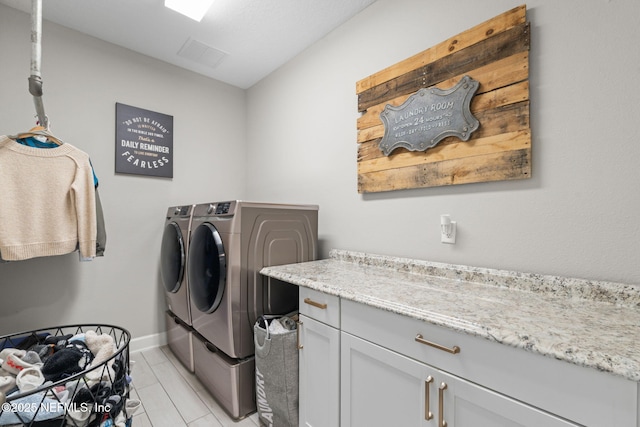 washroom featuring washer and clothes dryer and cabinets