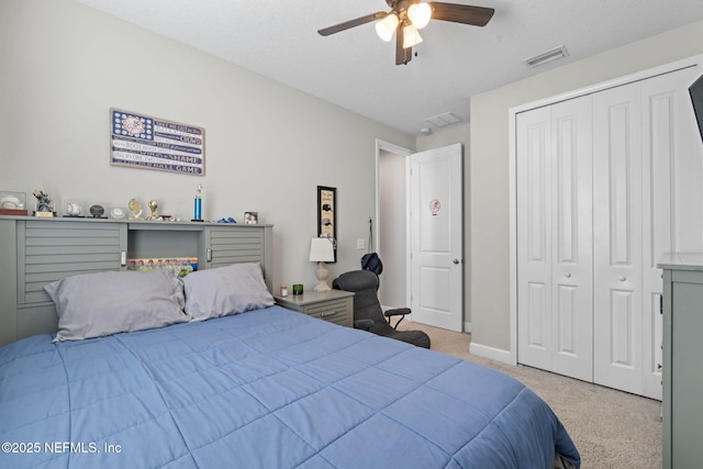 carpeted bedroom featuring ceiling fan and a closet