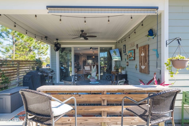 view of patio featuring ceiling fan, a grill, and exterior bar