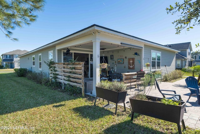 back of house with a yard and a patio