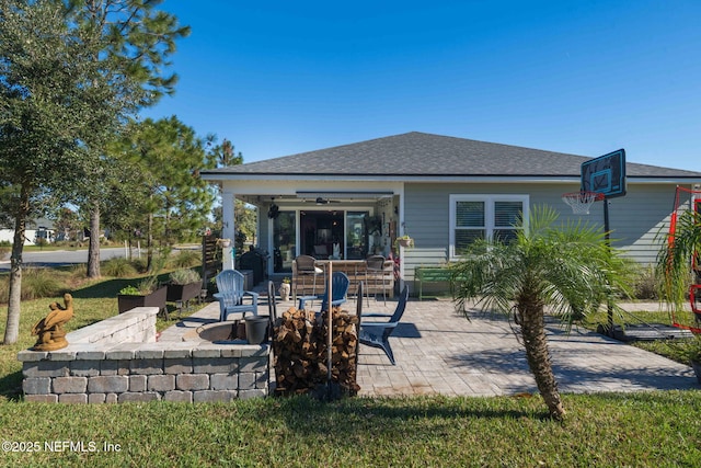 rear view of property with ceiling fan and a patio area