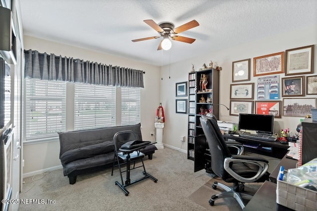 carpeted home office with ceiling fan and a textured ceiling