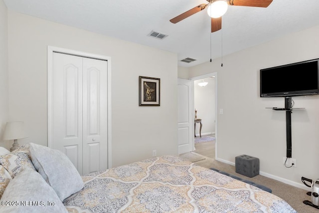 bedroom featuring ceiling fan, a closet, and light colored carpet