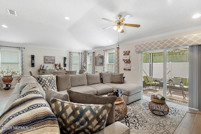 living room featuring light wood-type flooring, ceiling fan, and crown molding