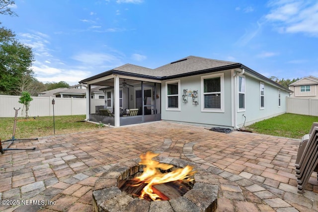 back of property with a patio area, a sunroom, a yard, and an outdoor fire pit