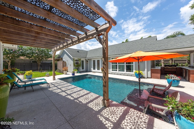 view of swimming pool with exterior kitchen, a pergola, and a patio area