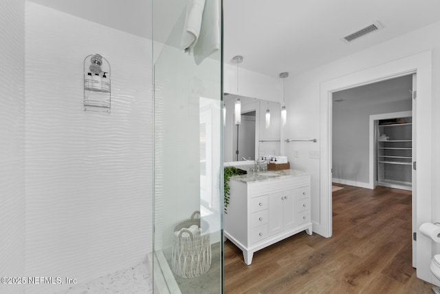 bathroom with vanity, hardwood / wood-style flooring, and a shower