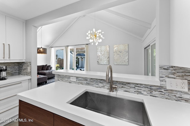 kitchen featuring dark brown cabinetry, sink, vaulted ceiling with beams, decorative light fixtures, and backsplash