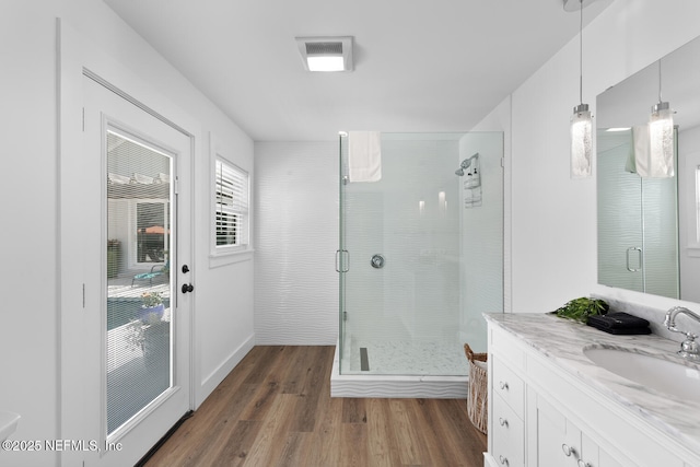 bathroom featuring wood-type flooring, vanity, and walk in shower