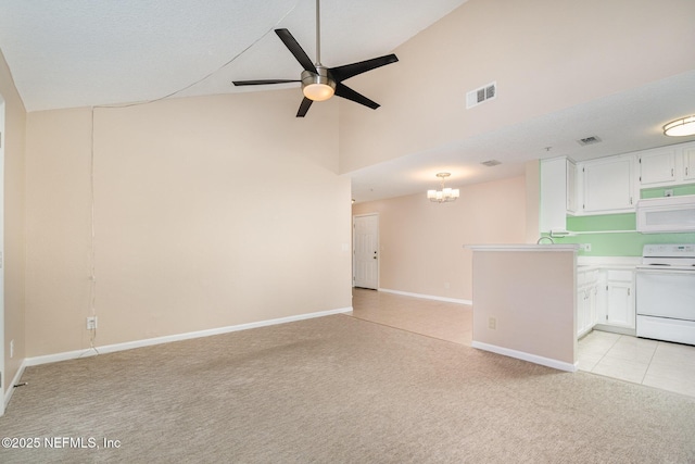 unfurnished living room with light tile patterned flooring, ceiling fan with notable chandelier, and high vaulted ceiling