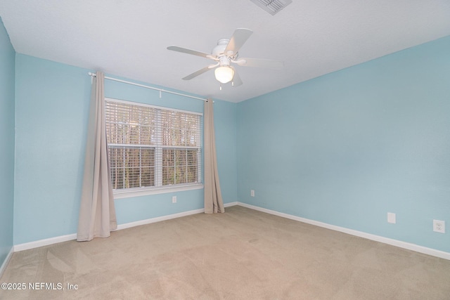 carpeted spare room featuring ceiling fan