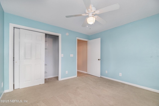 unfurnished bedroom with ceiling fan, a closet, and light carpet