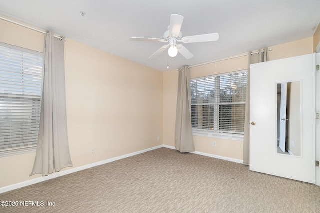 unfurnished room with ceiling fan and carpet floors