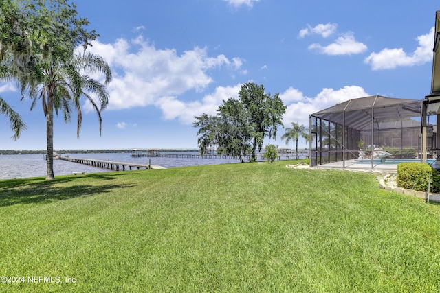 view of yard featuring glass enclosure and a water view