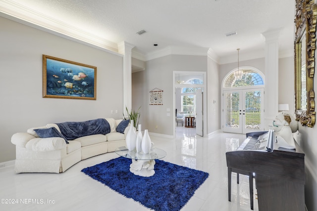 living room featuring an inviting chandelier, french doors, crown molding, ornate columns, and a textured ceiling