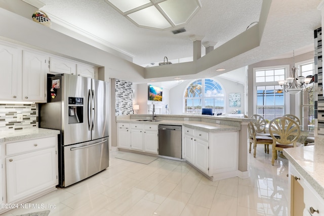 kitchen featuring white cabinetry, sink, stainless steel appliances, backsplash, and a textured ceiling