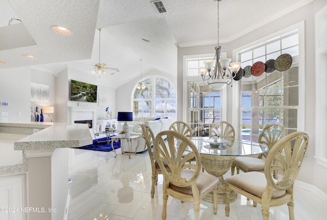 dining space featuring lofted ceiling, ceiling fan with notable chandelier, and a textured ceiling