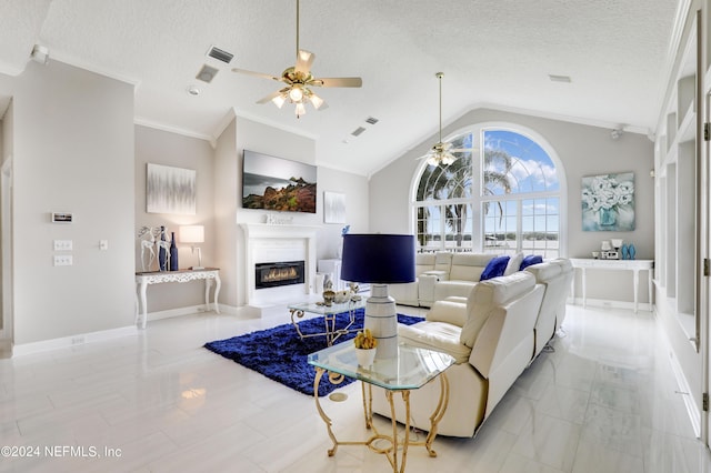 living room featuring lofted ceiling, ceiling fan, a textured ceiling, and ornamental molding