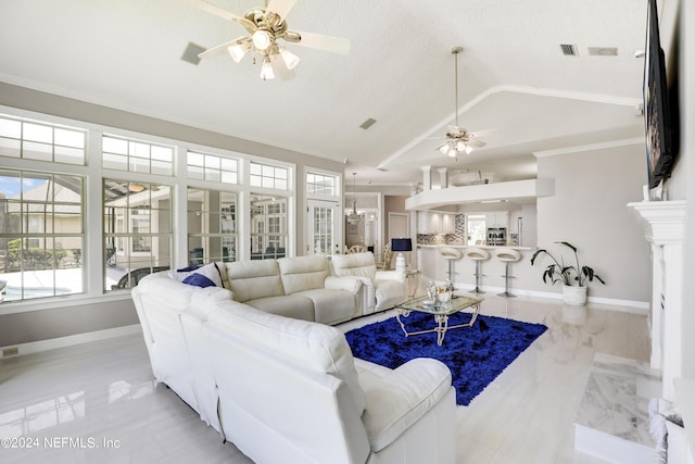 living room with a textured ceiling, vaulted ceiling, ceiling fan, and ornamental molding